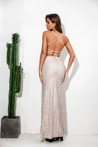 Detail of the backless sequin dress showing crisscross straps and shimmering pink fabric