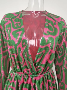 Detail showing the pink and green sequin pattern and deep V-neckline of the long sleeve romper