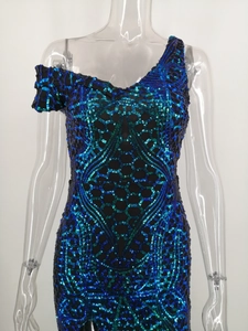 Detail of off-shoulder sequin dress with blue and green geometric embroidery patterns
