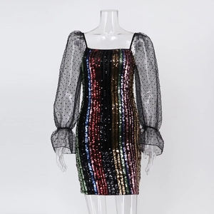 Détail d'une robe moulante à paillettes avec manches en tulle transparent à pois et volants