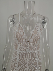 Détail rapproché de dentelle blanche et paillettes sur une robe de soirée sexy à col en V