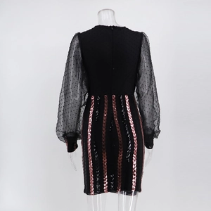 Détail des manches en tulle à pois et paillettes or rose sur cette robe courte noire