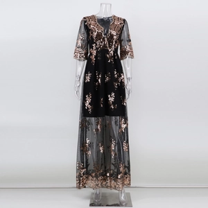 Détail de robe de soirée à paillettes noires avec broderie or rose et ourlet en tulle