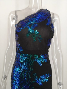 Nahaufnahme glitzernder blauer Pailletten-Blumenmuster und Rüschenschulter am schwarzen Kleid