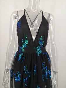 Detailed view of shimmering blue and green sequins on a sexy black V-neck evening gown