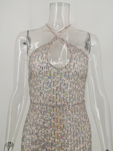Detail of holographic sequins on a silver halter neck evening dress with teardrop cutout