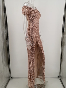 Detail of rose gold sequin embroidery on an off-shoulder evening dress with a side slit
