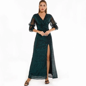 Detailed view of emerald green sequin evening gown with fringe sleeves and side slit