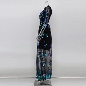 Détail d'une robe de soirée avec paillettes émeraude sur tulle noir et coupe longue