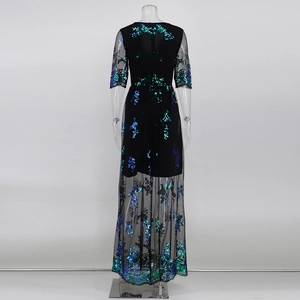 Détail macro d'une robe de soirée noire avec paillettes bleu-vert et broderie de dentelle florale