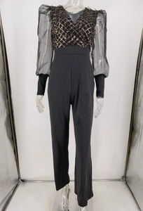 Detail of sequin diamond pattern with deep V-neck and mesh sleeves on jumpsuit