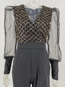 Detail of V-neck sequin romper featuring sheer puff sleeves and gold lattice patterns