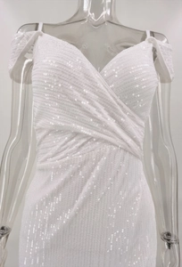 Close-up detail of white sequined evening dress featuring V-neck and spaghetti straps