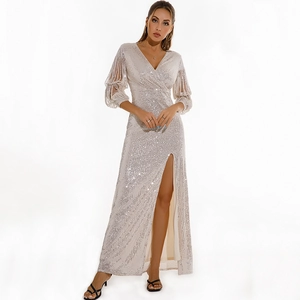 Detailed view of sequined evening gown with deep V-neck, fringe sleeves, and high side slit
