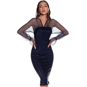 Close-up of dark blue sequin evening dress with sheer polka dot mesh and puff sleeves