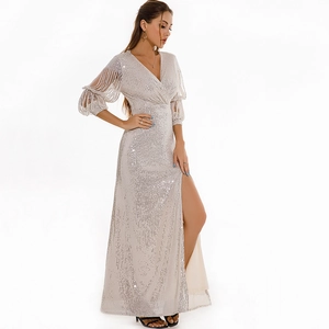 Detail of elegant sequin evening dress featuring tassel sleeves and sexy high side slit