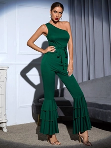 Detail of elegant dark green one-shoulder jumpsuit with layered ruffled hem design
