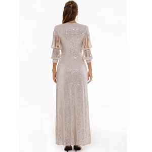 Detail of champagne sequin gown with shimmering fabric and tiered fringe sleeves