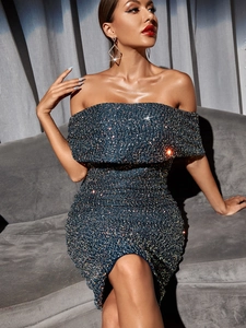 Detailed view of the sparkling green sequin fabric on the off-shoulder evening dress