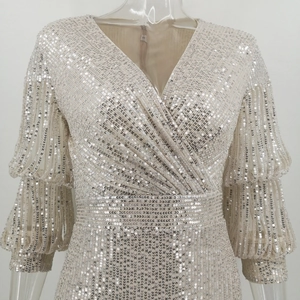 Detailed macro view of silver sequin dress with elegant deep V-neck and puff sleeves
