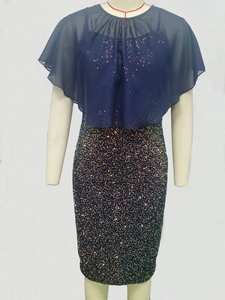 Detailed close-up of dark blue sequined dress featuring a layered chiffon shawl overlay