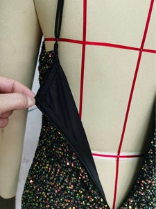 Detail of hidden zipper and colorful sequins on a sexy black party dress for women