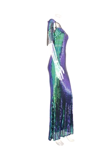 Detailed view of green sequined evening dress featuring fringe shoulder and vertical stripes
