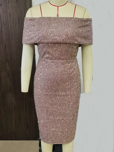Macro detail of the sparkling rose gold sequins on a fitted strapless cocktail dress