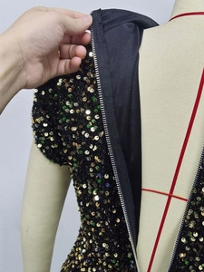 Detailed close-up of metallic zipper and premium black lining on a sequin dress