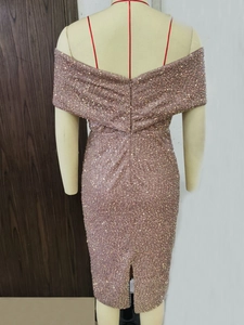 Detail view of the sequin cocktail dress featuring a back zipper and split hem design