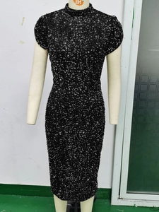 Detail of a sexy black sequin dress featuring a mock neck and elegant cap sleeves design