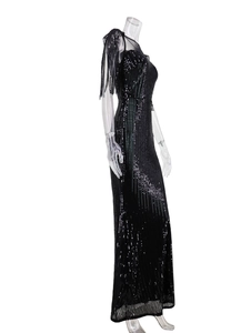 Detailed close-up of a black sequin evening gown with mesh stitching and long shoulder fringe