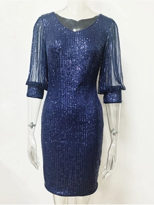 Détail d'une robe à paillettes bleu marine avec manches en tulle et rayures de sequins