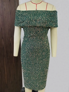 Detailed close-up of emerald green sequins on a strapless vintage evening party dress