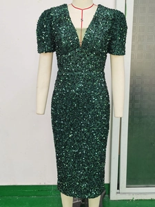Detailed view of deep green sequined dress with a deep V-neck and short sleeves