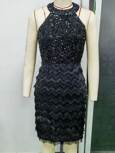 Détail d'une robe licou à paillettes noires avec des franges étagées et un motif de vagues en V