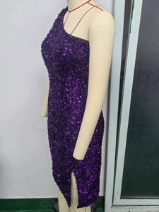 Détail d'une robe violette à paillettes à une épaule avec fente latérale haute sur un mannequin