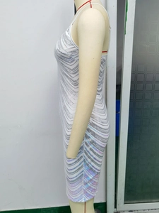 Close-up of white sequin dress showing shimmering wave patterns and thin straps