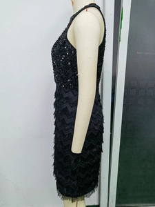 Vue latérale détaillée des paillettes noires et des franges de cette robe de soirée