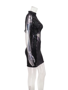 Détail de robe noire à paillettes avec découpe à la taille et manches à franges chic
