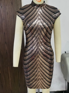 Detailed view of the sparkling gold sequins chevron pattern on the fitted dress fabric