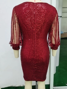 Détail de robe à paillettes bordeaux avec manches en mesh et franges scintillantes