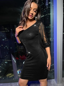 Détail d'une robe sexy à paillettes noires avec coupe asymétrique et manches à franges