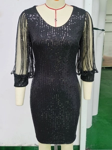 Détail des manches en résille avec paillettes noires sur une robe de soirée à col en V