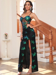 Detail of sheer mesh bustier and emerald green sequin floral embroidery on a black dress