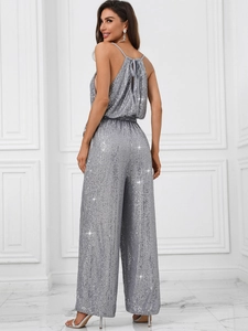 Back view of a shimmering silver sequin halter neck jumpsuit with an elegant open back design