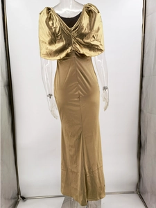 Elegant gold satin evening gown with open back and cape sleeves on mannequin