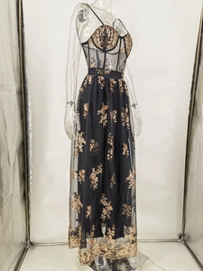 Detail eines schwarzen Tüll-Abendkleids im Korsett-Stil mit goldenen Paillettenstickereien