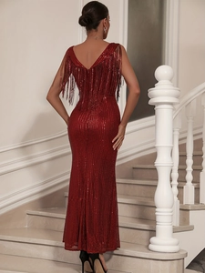 Détail de robe de soirée rouge à paillettes avec pampilles aux épaules et dos nu en V