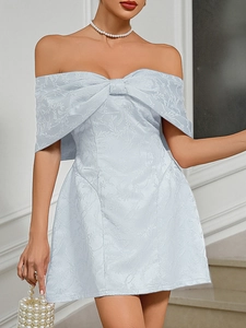 Detail of light blue strapless dress featuring a large bow and floral jacquard fabric